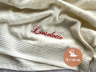 Beigefarbenes Handtuch mit roter Stickerei in weichem, hochwertigem Stoff von HeldenFaden. Perfekt für personalisierte Gestaltung.