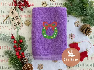 Lila Handtuch mit grünem Kranz-Stickmotiv und roten Details, hochwertig bestickt von HeldenFaden. Ideal für personalisierte Geschenkideen.