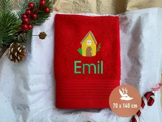 Rotes Handtuch mit Lebkuchenhaus-Stickmotiv und grünem personalisierten Schriftzug von HeldenFaden. Perfekt für besondere Anlässe.