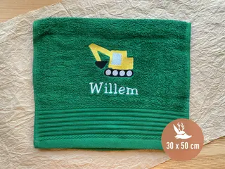Grünes Handtuch (30x50 cm) mit gelbem Bagger-Stickmotiv und personalisierter weißer Schrift. Ideal für Kinder oder personalisierte Geschenke.
