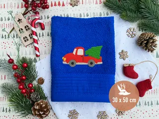 Blaues Handtuch (30x50 cm) mit gesticktem Motiv eines roten Autos, das einen Weihnachtsbaum transportiert. Ideal für die Weihnachtszeit.